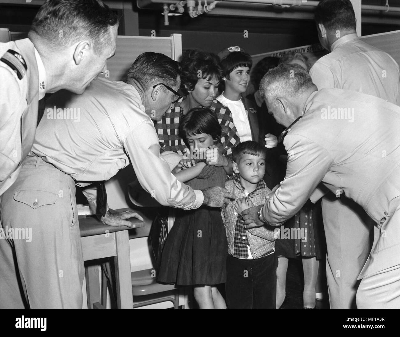 Stati Uniti Servizio Pubblico di Sanità (PHS) rappresentanti immunizzando un famiglia cubana, massa cubano-emigrazione, Miami, Florida, ottobre 1965. Immagine cortesia di centri per il controllo delle malattie (CDC). () Foto Stock