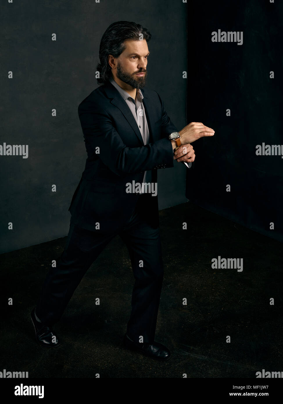 Uomo in un business suit, indossare un orologio in varie posizioni. Foto Stock