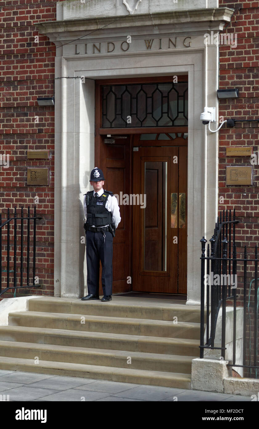 London, Regno Unito - 23 aprile 2018 un giovane la Metropolitan police officer, PC Tyler O'Hare le guardie lo sportello anteriore del privato Lindo ala del St. Mary's Hospital dove Catherine, duchessa di Cambridge è un nuovo bambino a St. Mary's Hospital, Paddington, Londra, Inghilterra, Regno Unito, Europa. Fotografo: Equinox caratteristiche prese Data: 20180423 Tempo: 17434940 Foto Stock