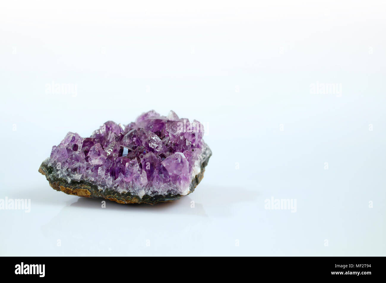 Isolato preziosa gemma ametista con sfondo bianco. Si tratta di un viola / viola varietà di quarzo spesso usato in gioielleria. Foto Stock