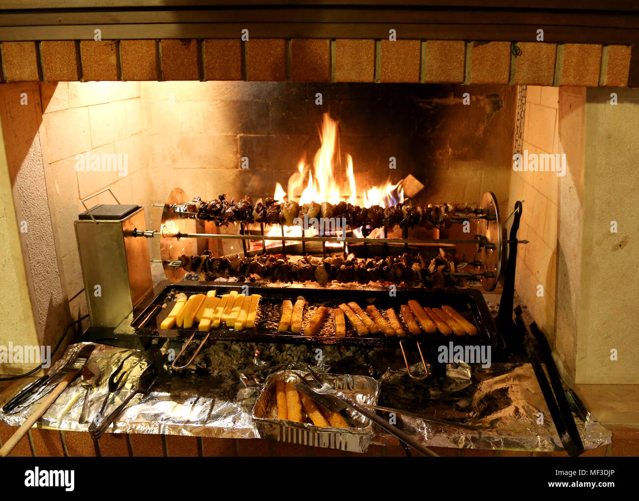 Grigliata di uccelli e la polenta sul camino durante una fiera di villaggio Foto Stock