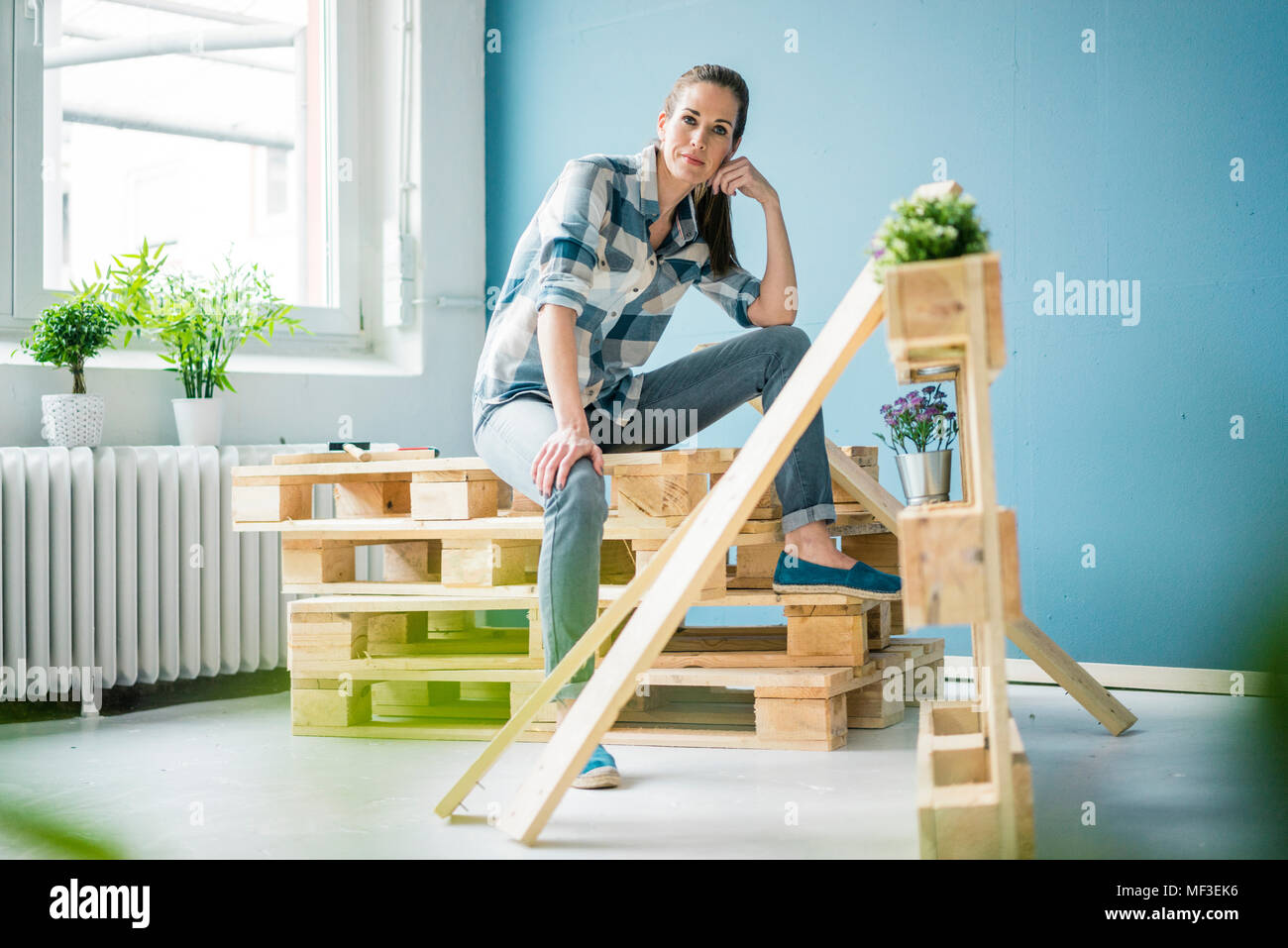 Bella donna di ristrutturare la sua casa con pallet Foto Stock