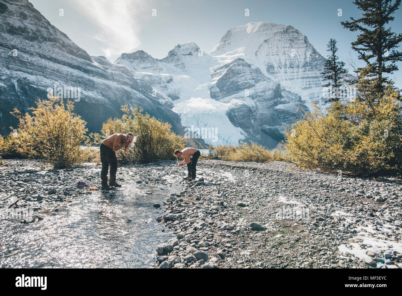 Canada, British Columbia, Monte Robson Provincial Park, due uomini lavaggio in un ruscello Foto Stock