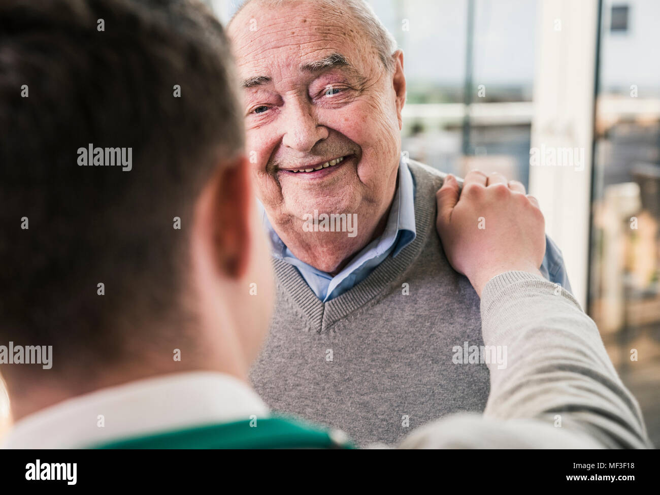 Senior uomo sorridente al giovane uomo Foto Stock