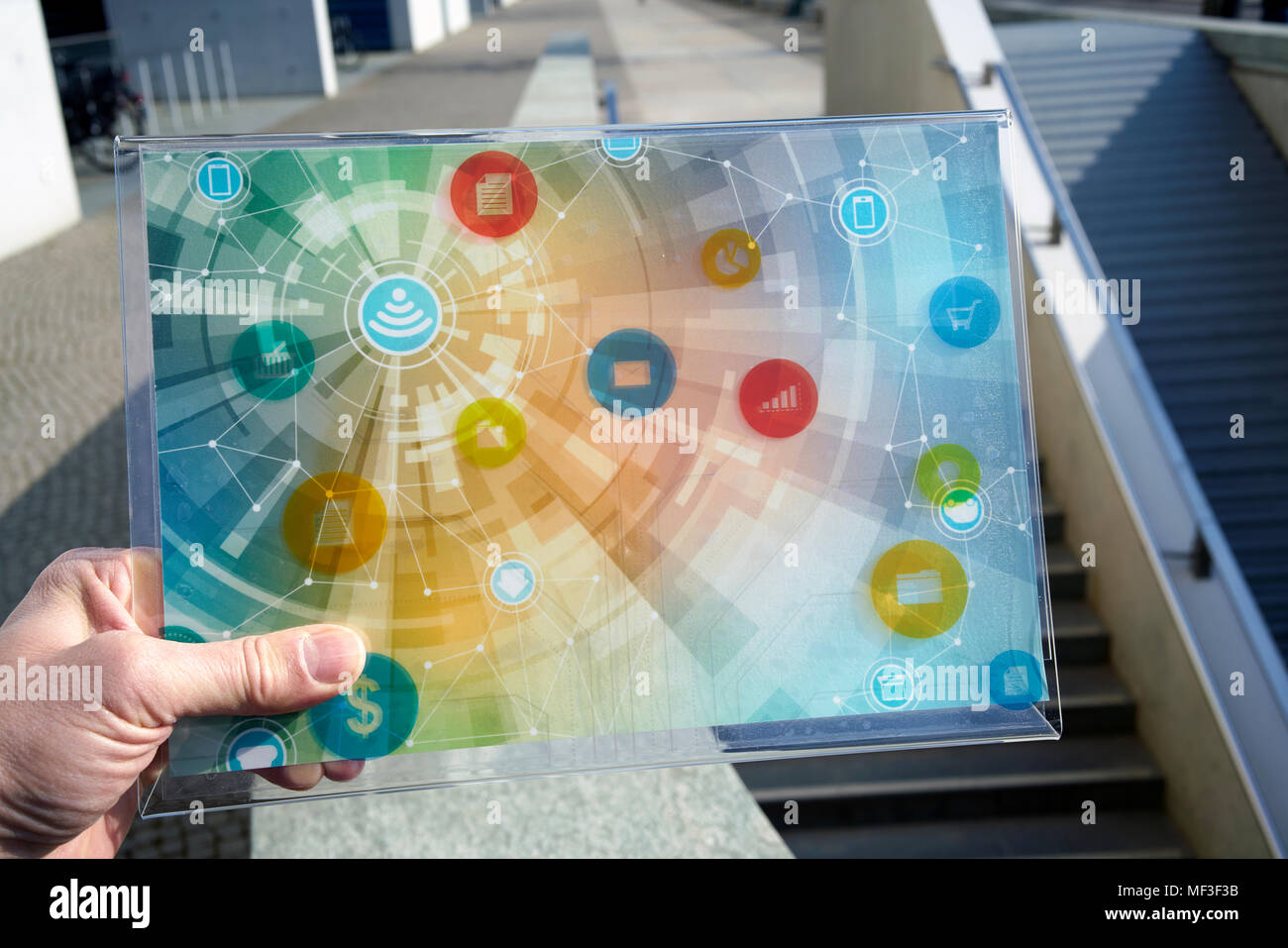 Mano che tiene il dispositivo futuristico con icone digitali Foto Stock