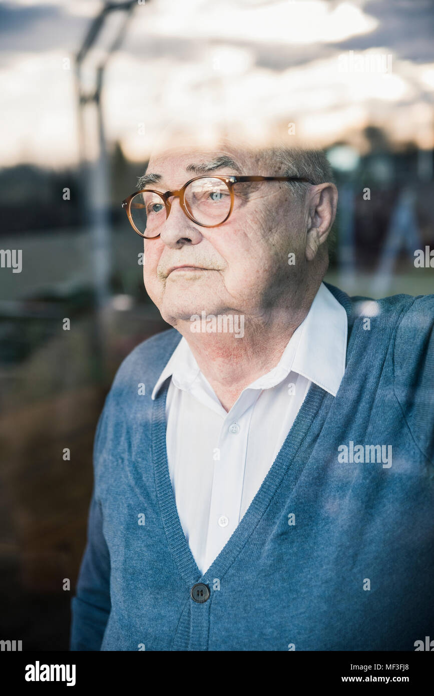 Ritratto di grave uomo senior presso la finestra Foto Stock