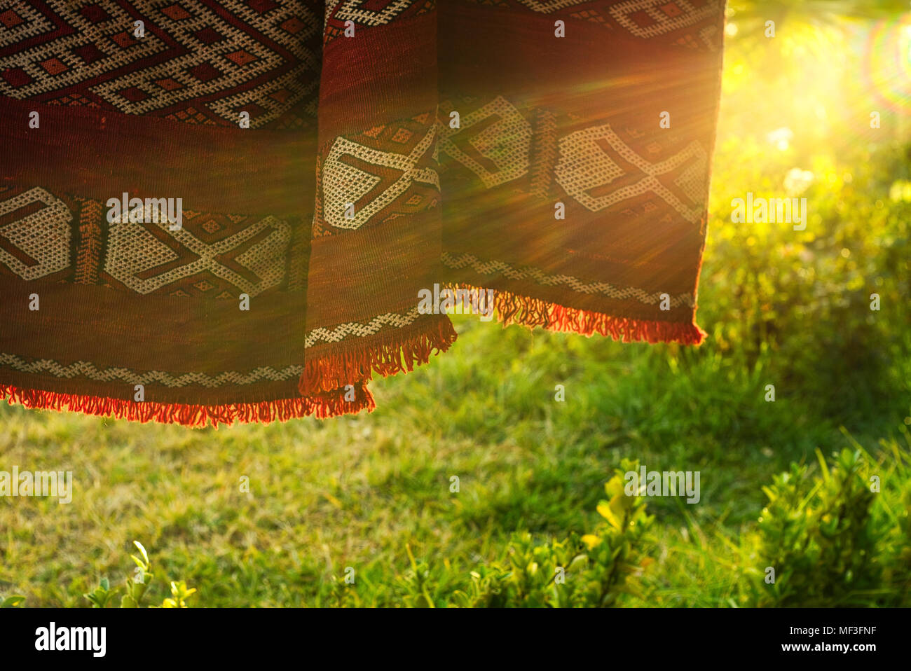 Marocchina tradizionale tappeto berbero appeso all'aperto in serata la luce del sole. Foto Stock