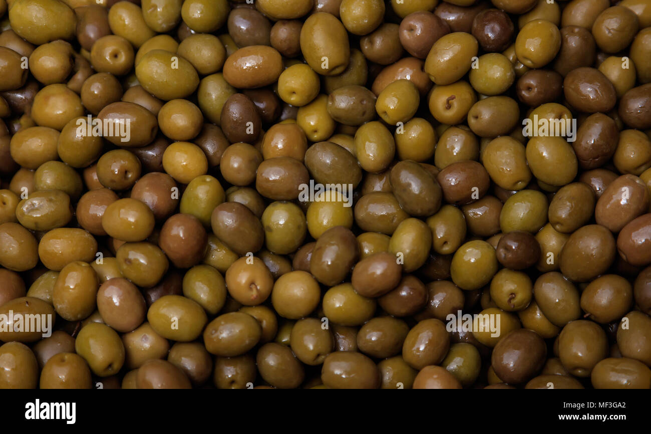 Shiny olive verdi sfondo. Sani e freschi snack. Closeup, vista dall'alto. Foto Stock