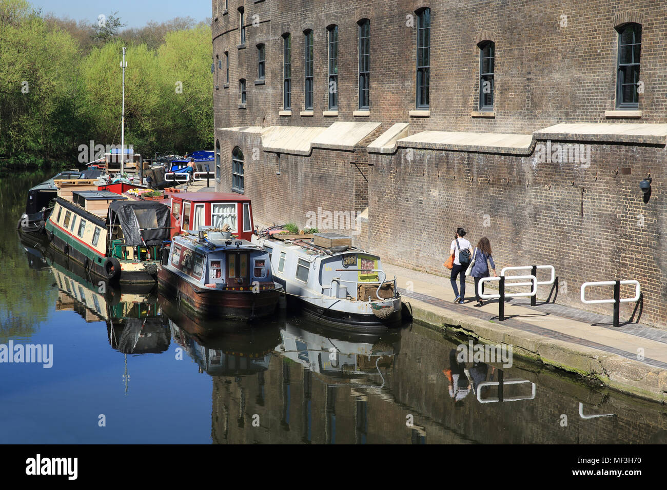 Camminando lungo la strada alzaia sul Regents Canal a Kings Cross, a fianco del carbone rigenerato in ufficio CYD, London, Regno Unito Foto Stock