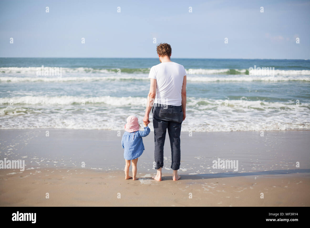 Paesi Bassi, Renesse, padre e figlia in piedi in spiaggia Foto Stock