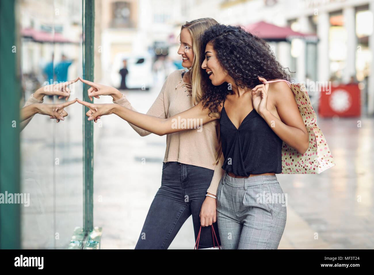 Due giovani donne alla ricerca nella finestra del negozio Foto Stock