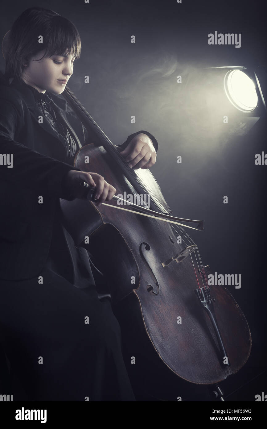 Il violoncellista riproduzione di musica classica in violoncello contro uno sfondo nero Foto Stock