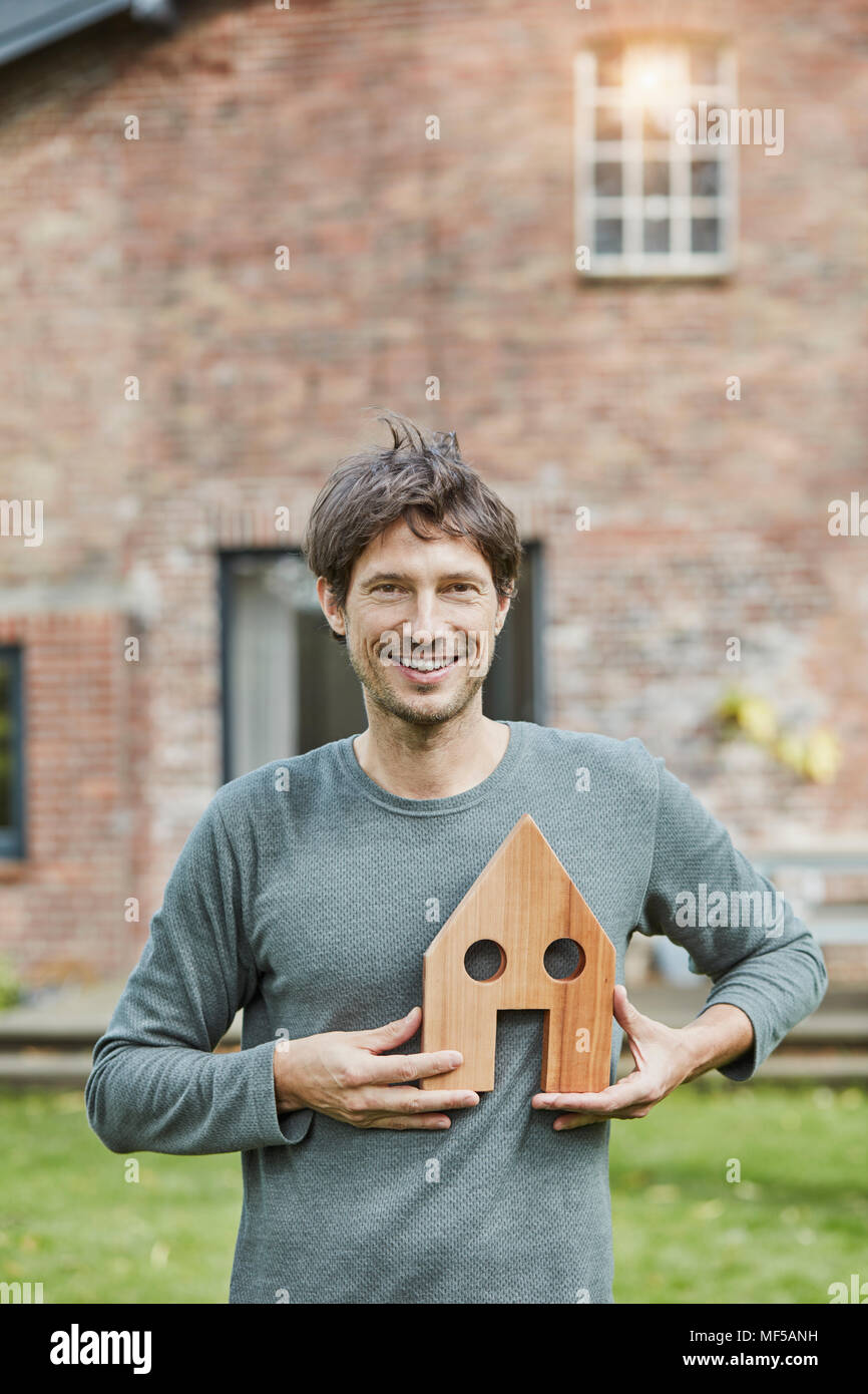 Ritratto di uomo sorridente davanti a casa sua azienda modello di casa Foto Stock