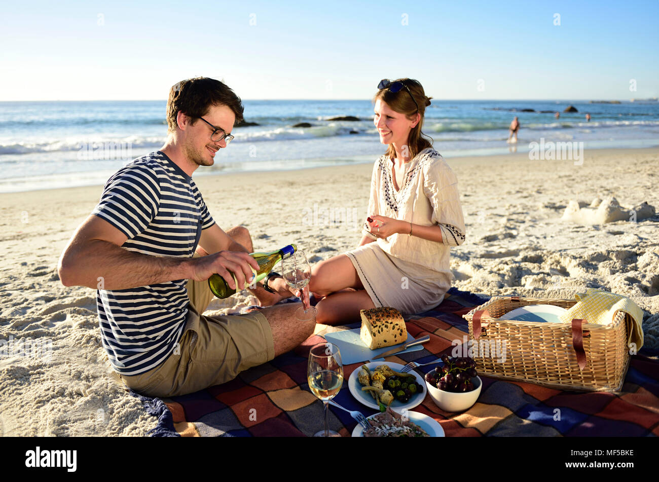 Felice coppia avente un picnic sulla spiaggia Foto Stock