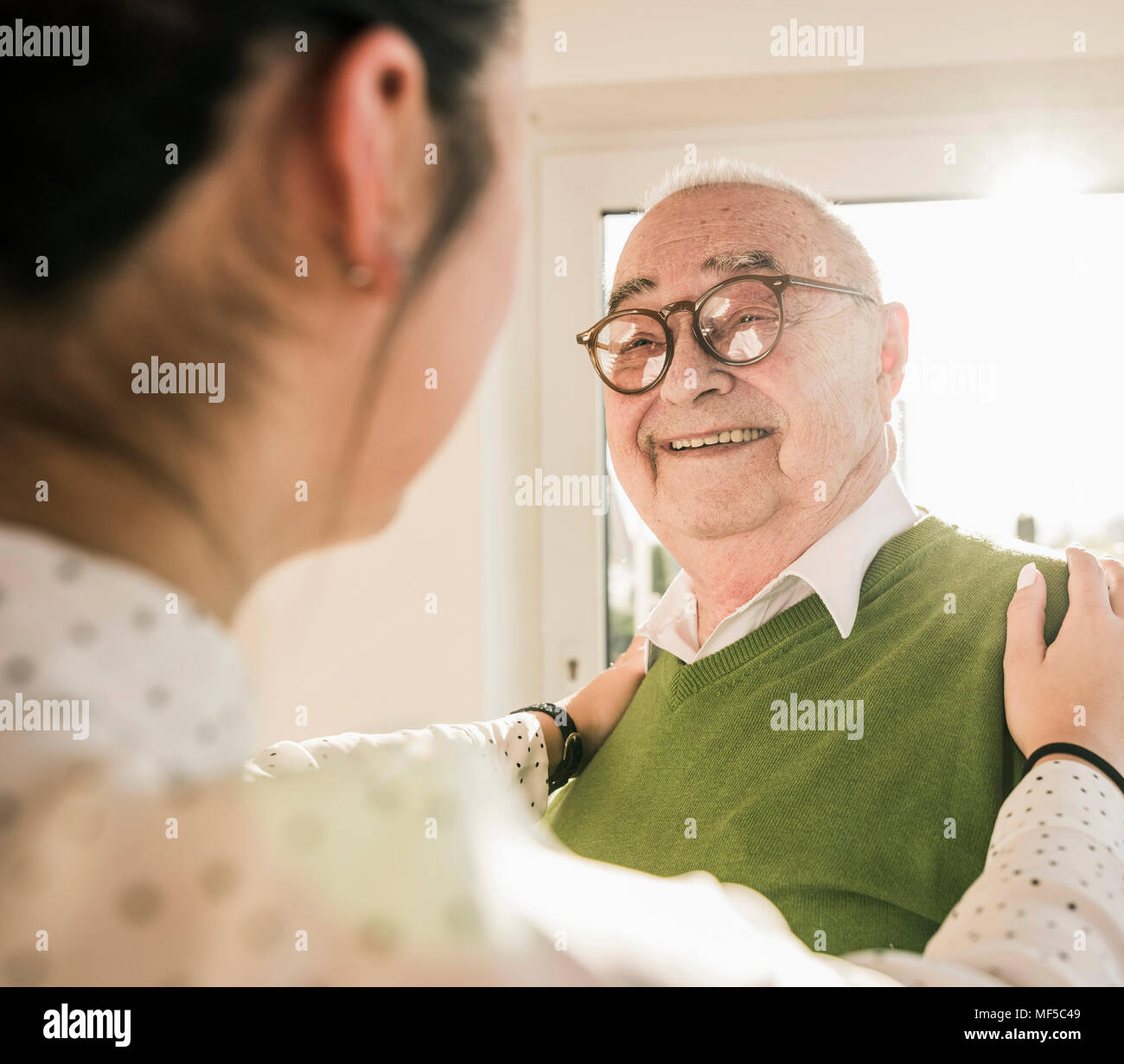 Senior uomo sorridente al giovane donna Foto Stock