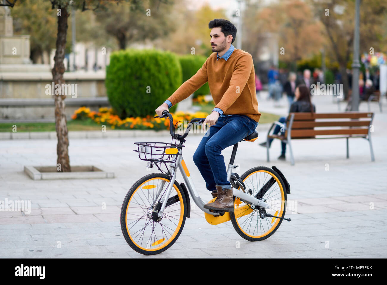 Spagna, Andalusia, Granada. Bel giovane sulla condivisione in bicicletta in città. Il concetto di stile di vita. Foto Stock