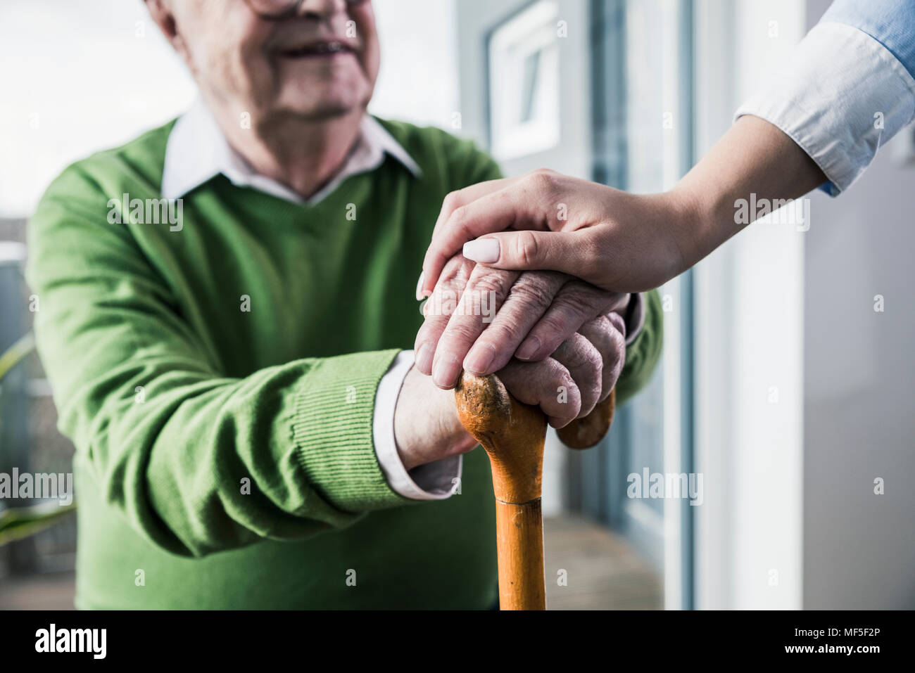 Close-up di donna holding senior mano d'uomo appoggiato su di canna da zucchero Foto Stock