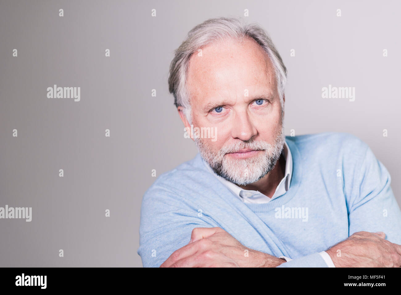 Ritratto di seriousg uomo maturo di fronte a uno sfondo grigio Foto Stock