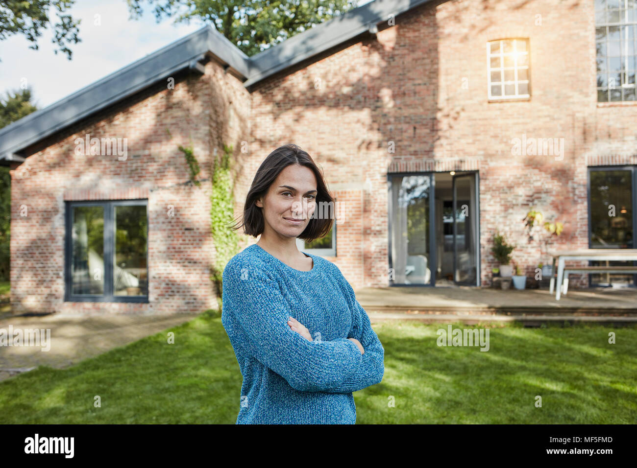 Ritratto di donna fiducioso nel giardino della sua casa Foto Stock