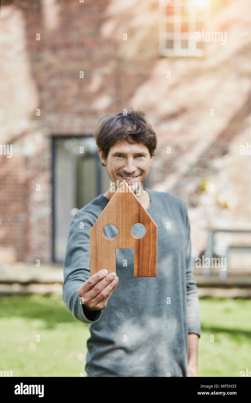 Ritratto di uomo sorridente davanti a casa sua azienda modello di casa Foto Stock