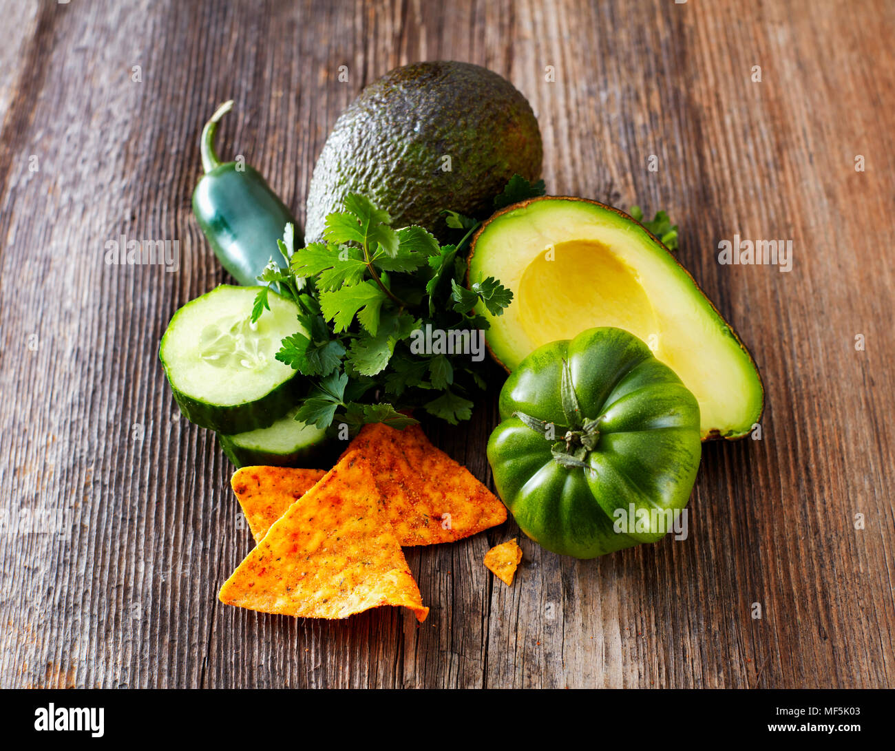 Avocado, tortilla chips, pomodoro verde, jalapenos, cetriolo, prezzemolo Foto Stock