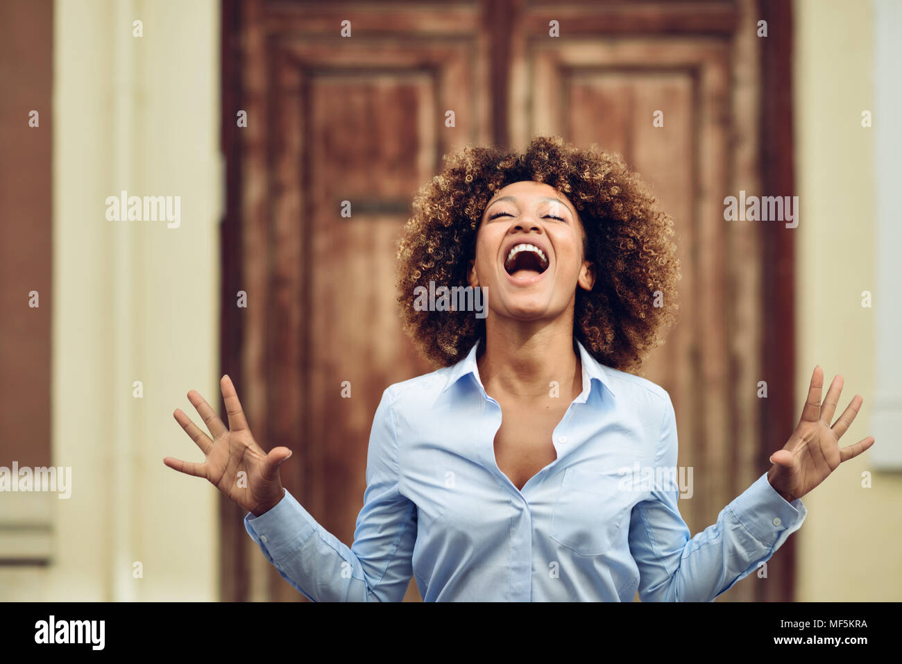 Spagna, Andalusia Malaga. Giovane donna nera, acconciatura afro, urlando in strada. Concetto di espressioni. Foto Stock