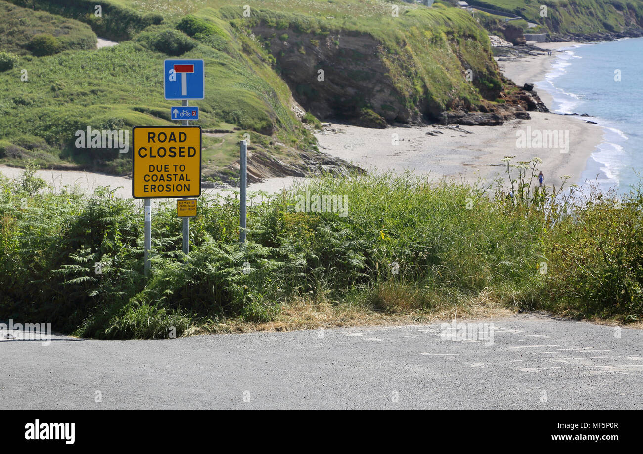 Strada chiusa a causa di erosione costiera a pendower spiaggia a sud della costa di Cornovaglia Foto Stock