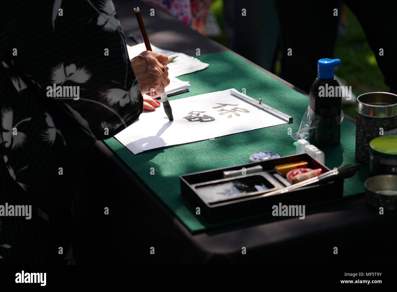 La calligrafia giapponese, irriconoscibile persona scrivendo caratteri kanji (traduzione inglese: riservato) con spazzola di inchiostro sulla carta Foto Stock