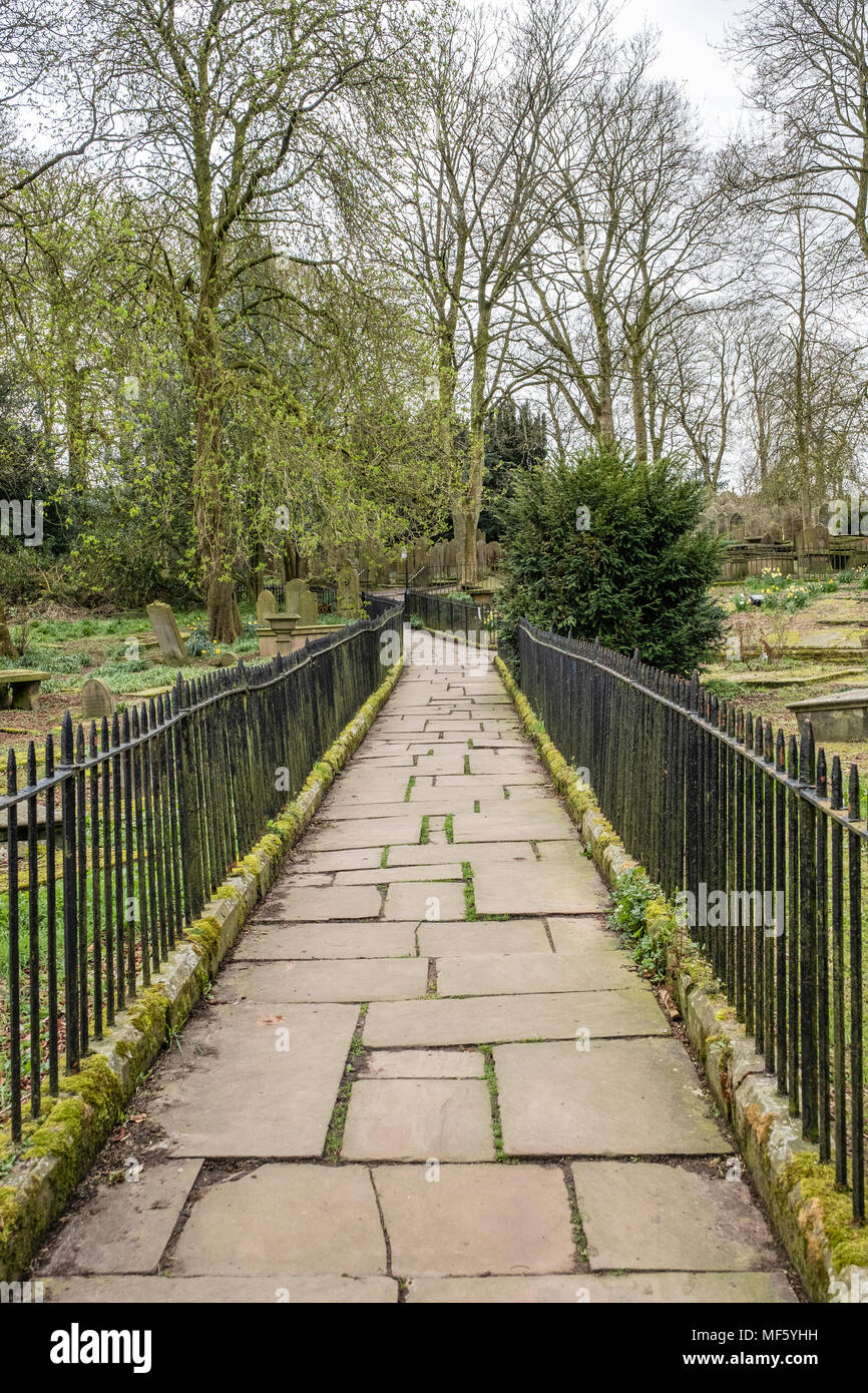 Inghilterra, nello Yorkshire, Haworth, sentiero verso il cimitero fuori Chiesa Parrocchiale. Foto Stock