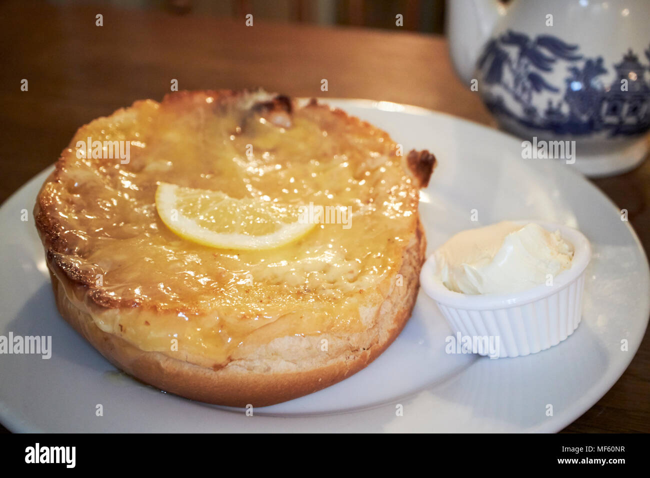 British tè alla crema con esclusivo sally lunns bun contemplati nella cagliata di limone in un teashop in Bath Somerset England Regno Unito Foto Stock