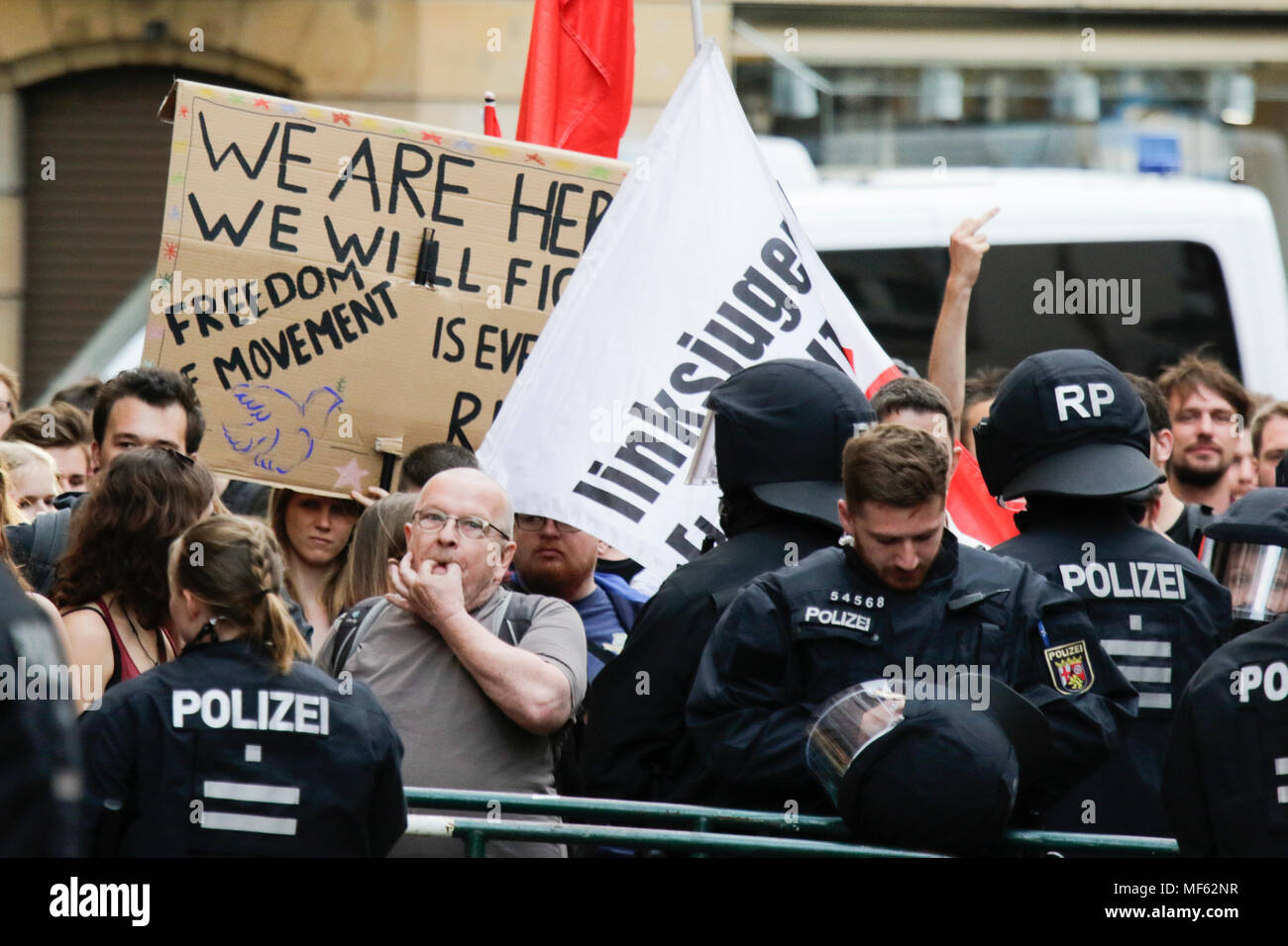 Mainz, Germania. 23 apr, 2018. Il contatore-manifestanti protesta con striscioni e bandiere appena al di fuori della vista da destra protestare, separati da funzionari di polizia. Intorno 50 a destra i dimostranti si sono stretti nel centro città di Magonza, per protestare contro il governo tedesco, per la chiusura delle frontiere e contro i rifugiati sotto lo slogan "erkel ha per andare'. Essi sono stati heckled da circa 350 contro i manifestanti. Credito: Michael Debets/Pacific Press/Alamy Live News Foto Stock