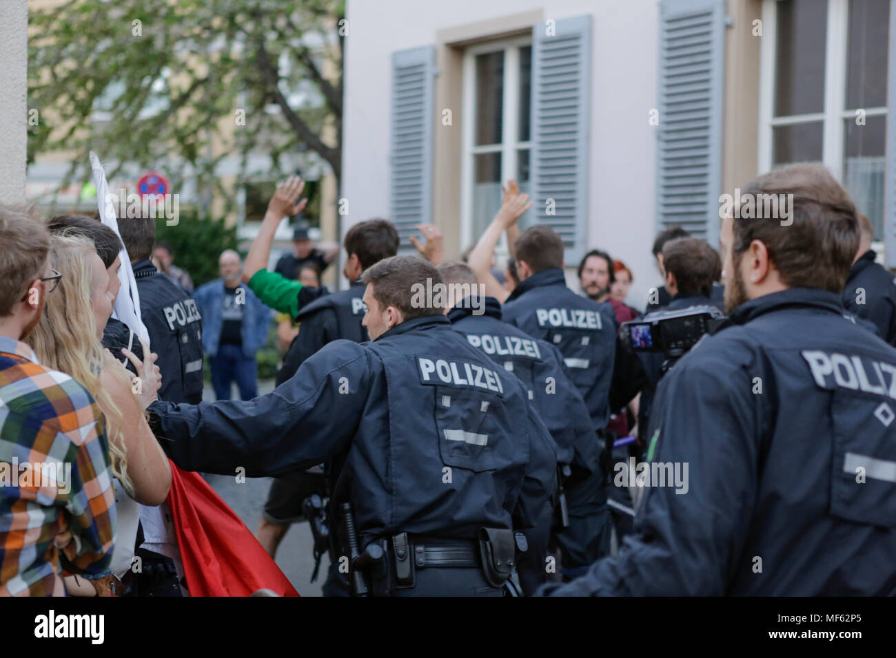 Mainz, Germania. 23 apr, 2018. Gli ufficiali di polizia manifestanti push su un lato, per fare spazio a destra i manifestanti per auto. Intorno 50 a destra i dimostranti si sono stretti nel centro città di Magonza, per protestare contro il governo tedesco, per la chiusura delle frontiere e contro i rifugiati sotto lo slogan "erkel ha per andare'. Essi sono stati heckled da circa 350 contro i manifestanti. Credito: Michael Debets/Pacific Press/Alamy Live News Foto Stock