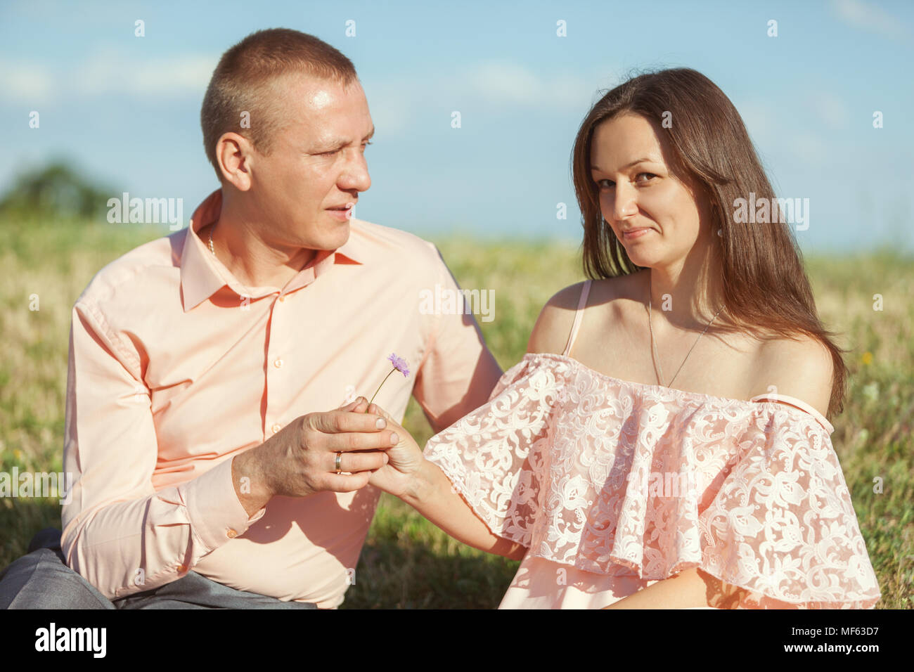 Ritratto di un bel giovane. L'uomo tiene fuori fiore alla donna. Foto Stock