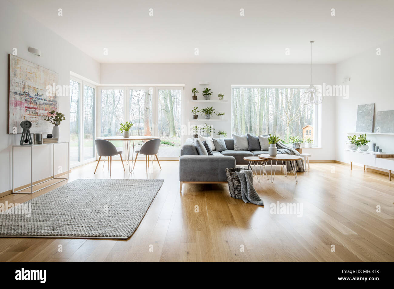 Bianco elegante salone interno con windows, grigio divano ad angolo e arte moderna poster Foto Stock