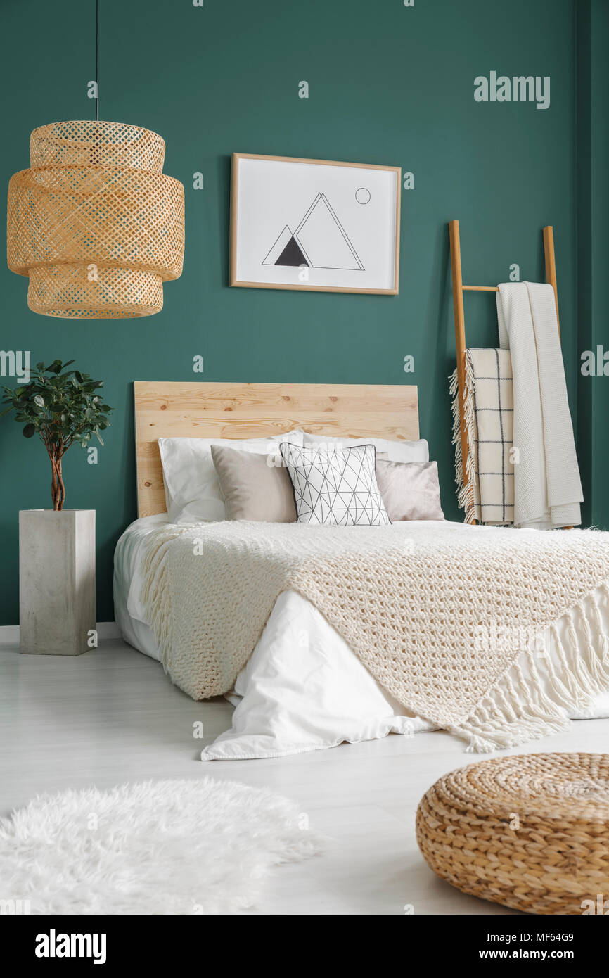 Pouf e pelliccia bianca sul pavimento vicino al letto con coperta in ... Pouf e pelliccia bianca sul pavimento vicino al letto con coperta in ...