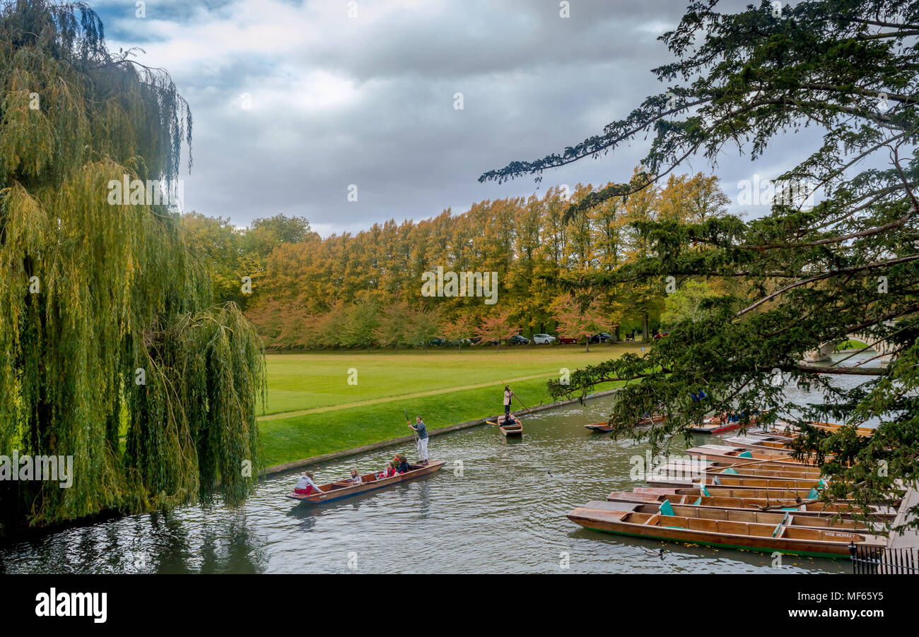 Cambridge, Regno Unito - Imbarcazioni parcheggiato in una riga e le persone che si godono la punting sul fiume Cam durante l estate a Cambridge Foto Stock