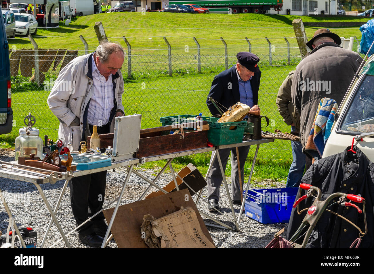 Gli uomini alla ricerca in una fase di stallo ad un auto boot vendita in una giornata di sole in Bandon, County Cork, Irlanda. Foto Stock