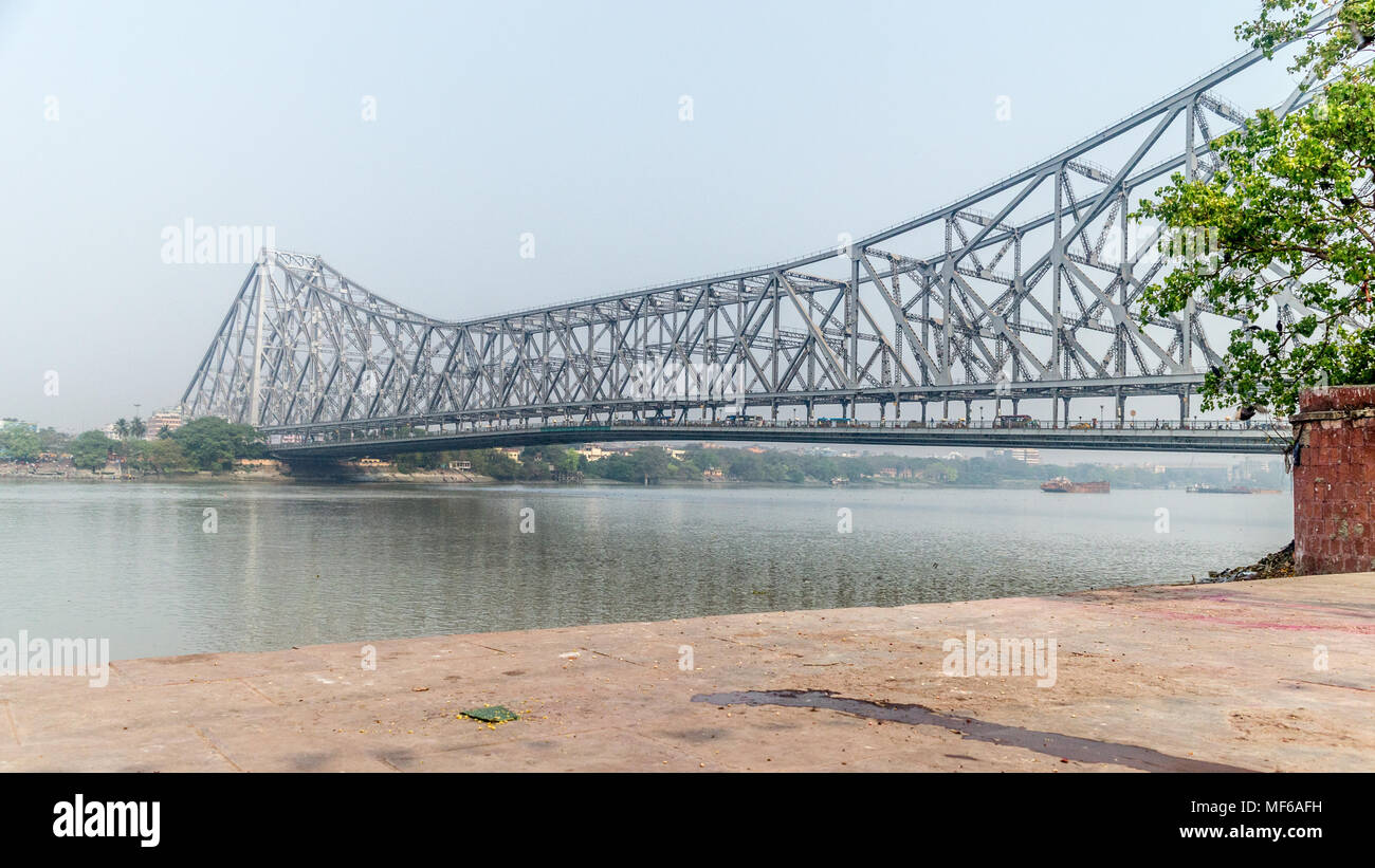 La famosa quella di Howrah Bridge, che collega la città gemella di Kolkata e quella di Howrah su una insenatura mattina di sole, Calcutta, West Bengal, India Foto Stock