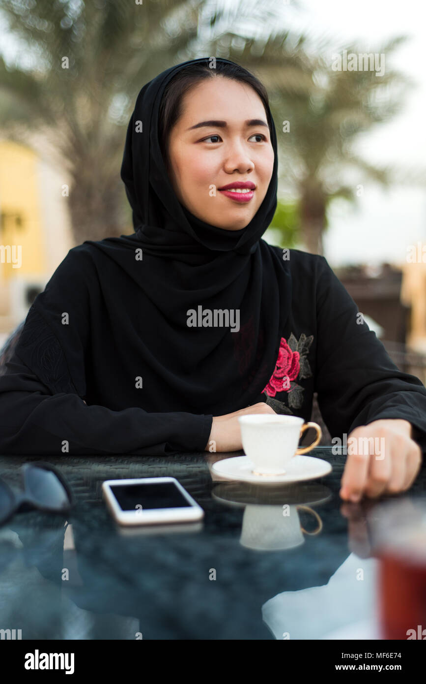 Donna musulmana seduti in un caffè bar all'aperto Foto Stock