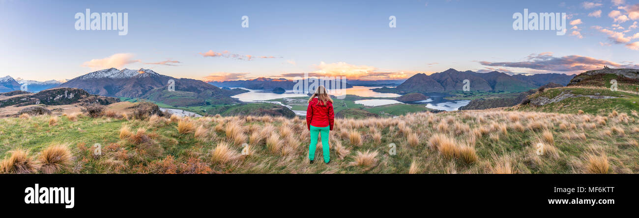 Escursionista affacciato sul lago Wanaka e montagne, picco roccioso, Glendhu Bay, Otago Southland, Nuova Zelanda Foto Stock
