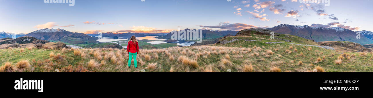 Escursionista affacciato sul lago Wanaka e montagne, picco roccioso, Glendhu Bay, Otago Southland, Nuova Zelanda Foto Stock