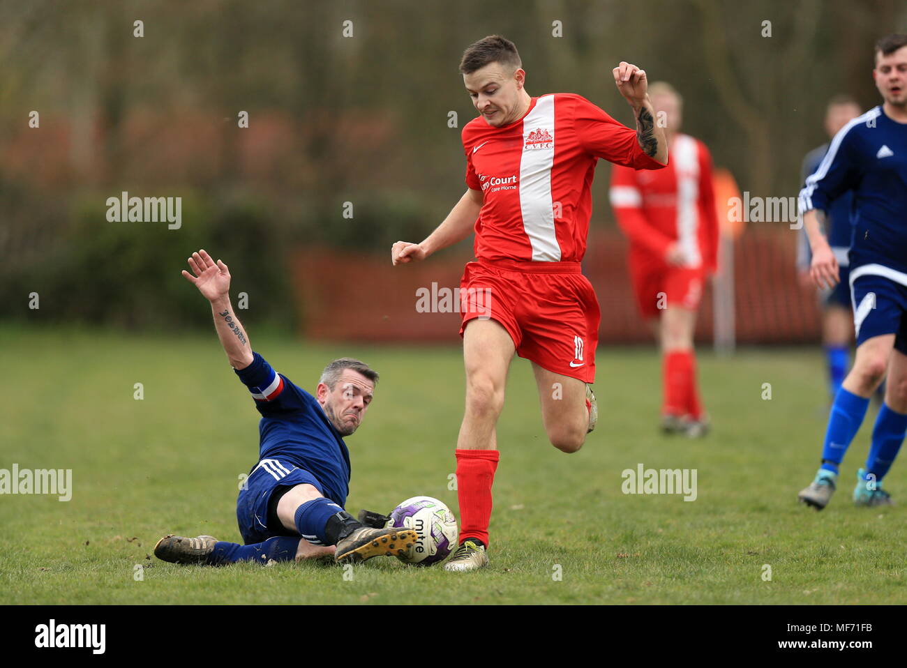 Un fabbro bracci FC player sfide per la sfera su una domenica mattina partita contro Charlwood Village si riserva in Redhill e lega di distretto Foto Stock