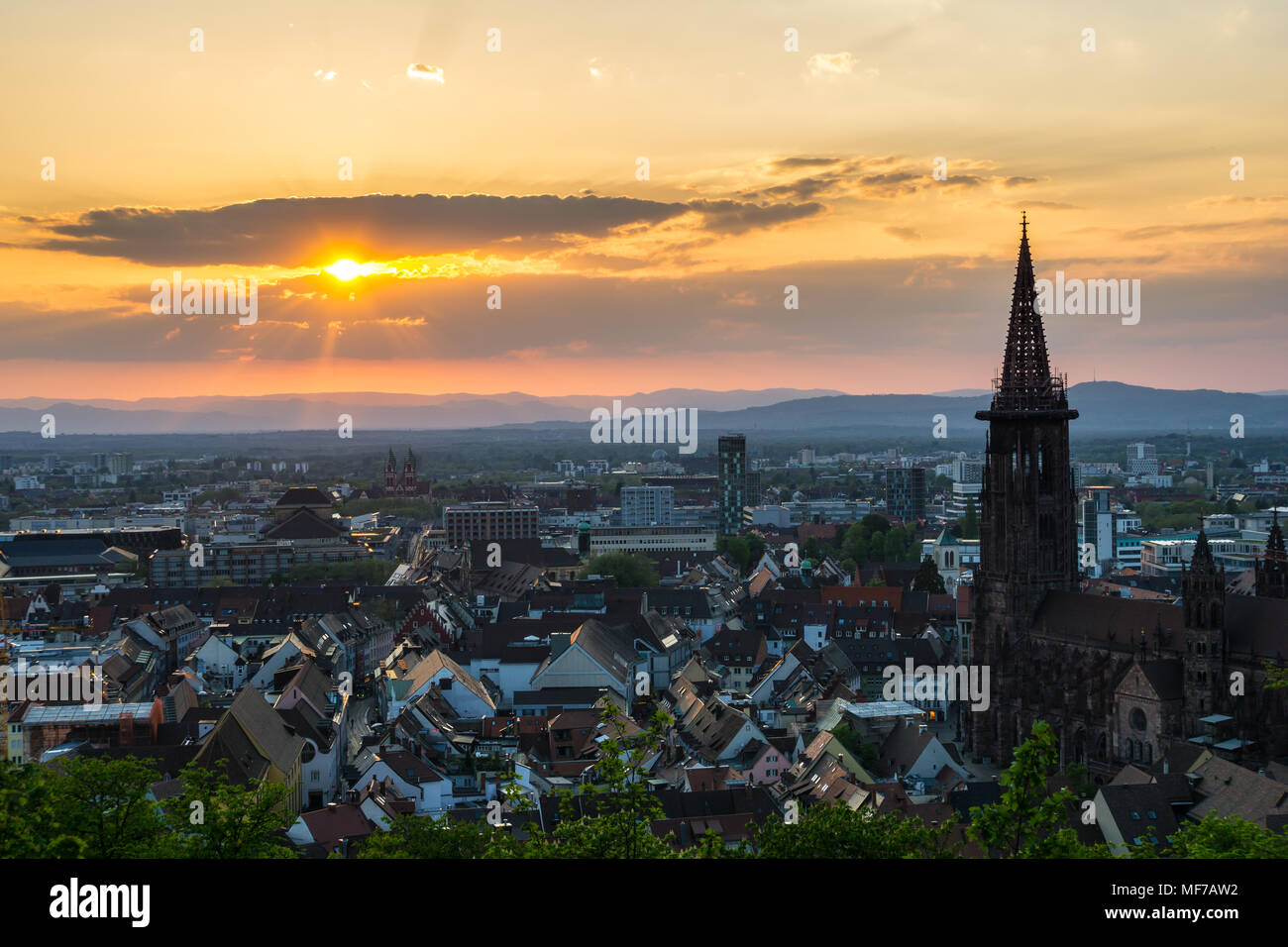 Germania, arancio caldo sole serale sui tetti della città di Freiburg im Breisgau dal di sopra Foto Stock