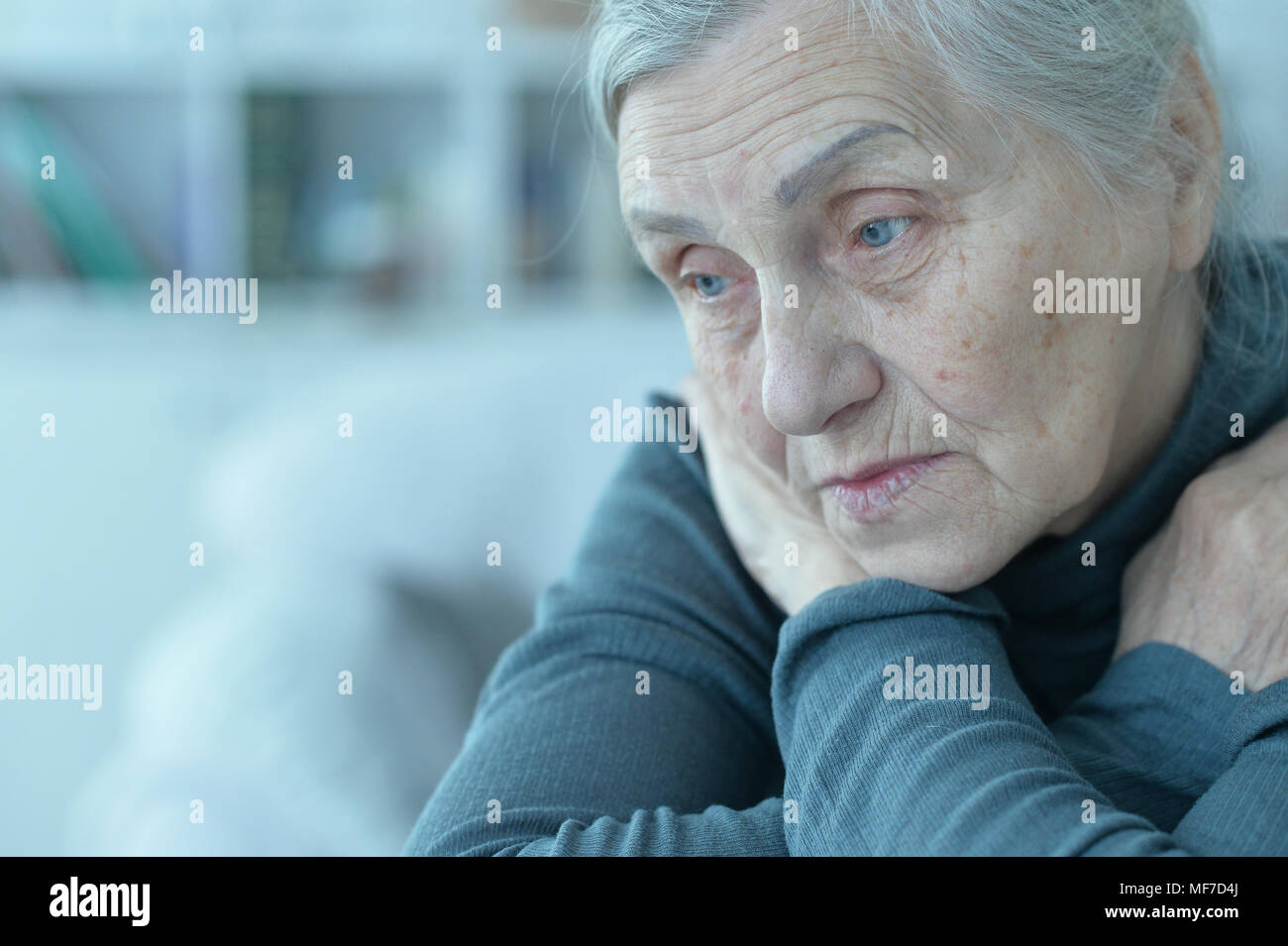 Close up ritratto di triste senior donna seduta a tavola Foto Stock