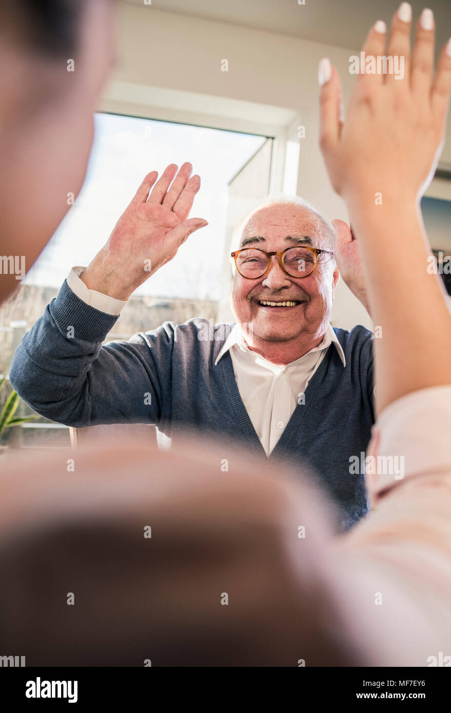 Felice l'uomo senior con le mani alzate guardando alla giovane donna Foto Stock