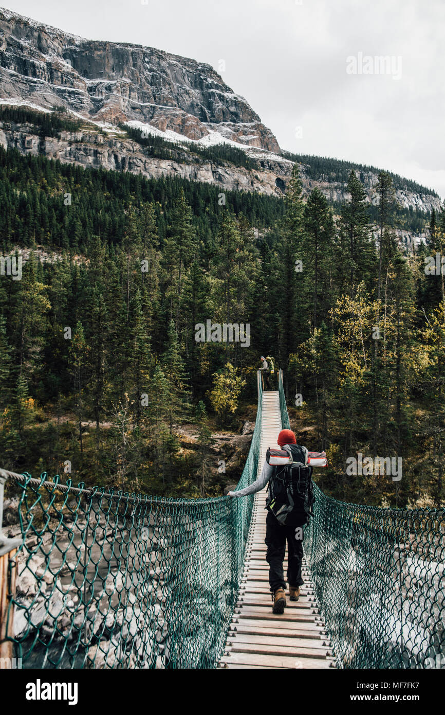 Canada, British Columbia, Monte Robson Provincial Park, due uomini sul ponte oscillante su Berg Lago Trail Foto Stock