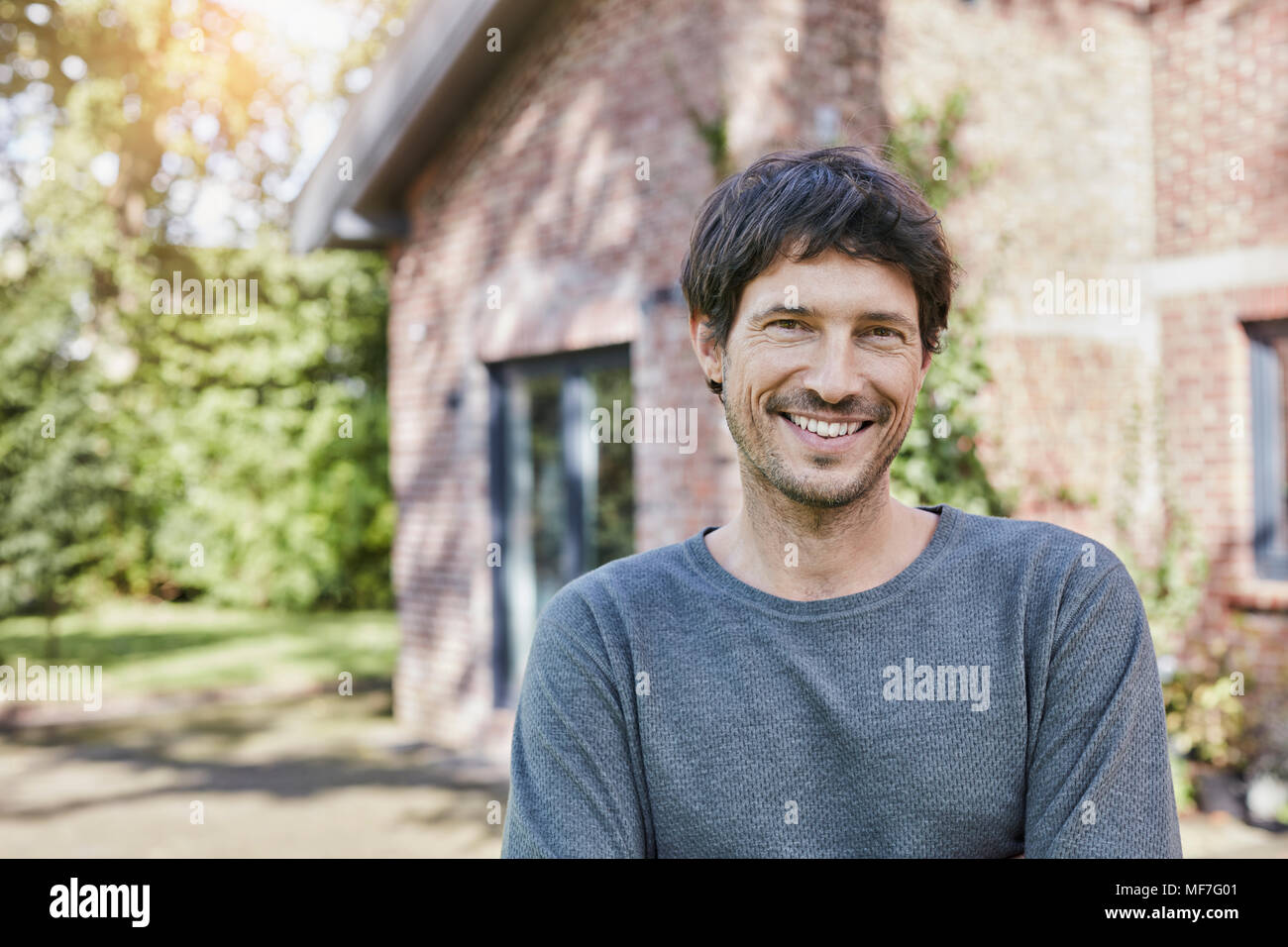 Ritratto di uomo sorridente davanti a casa sua Foto Stock