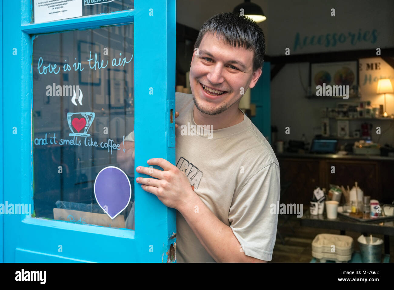 Ritratto di un sorridente torrefattore sulla porta di un caffè roastery Foto Stock