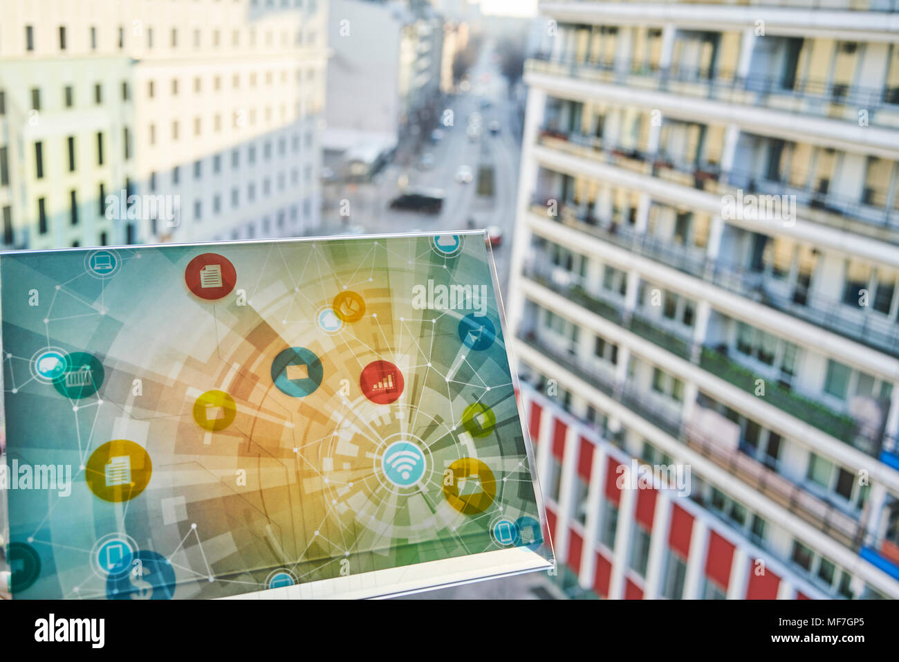 Dispositivo futuristico con icone digitali nella città Foto Stock