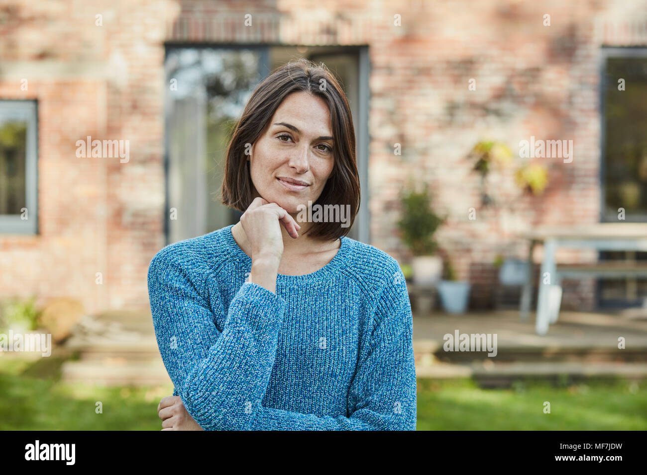 Ritratto di donna fiducioso nel giardino della sua casa Foto Stock